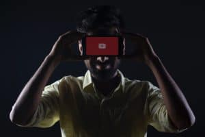 Mann nutzt YouTube auf seinem Handy, um mit Livestreams Geld zu verdienen