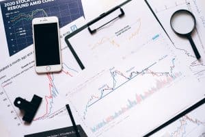 Charts, ein Handy und Papiere mit Aktienkennzahlen